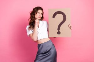 ハテナマークの紙を持つ女性