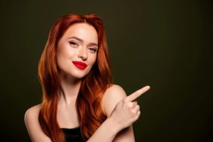 横を指さす女性